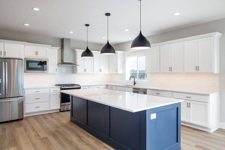 large kitchen featuring white cabinets with accent blue island. stainless steel appliances black modern pendant lights