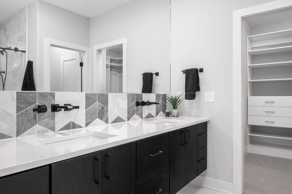 modern bathroom with black cabinets and white granite counter 