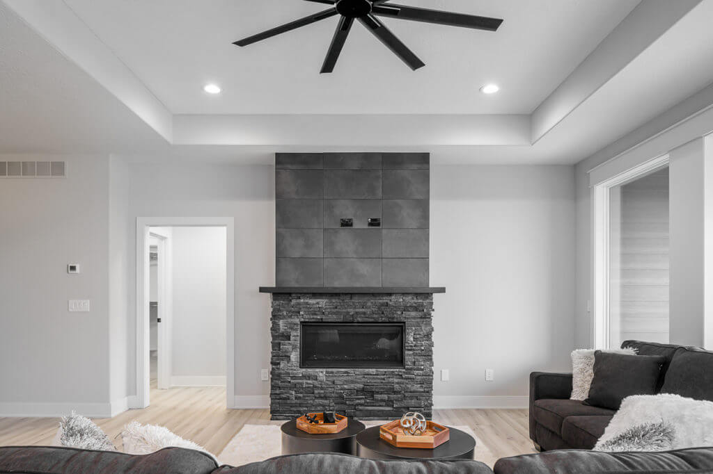 Living room with black stone fireplace by KRM custom homes