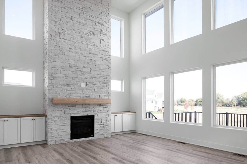 custom living room. lots of windows large stone fireplace and built-ins