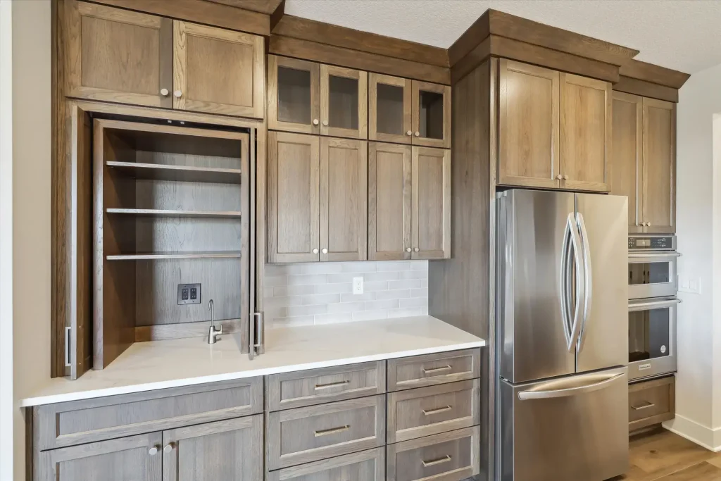 A kitchen counter includes a built-in coffee bar with a water faucet
