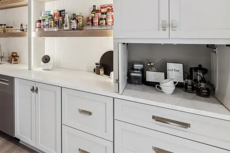 A kitchen cabinet includes a place to store coffee cups and coffee-making supplies