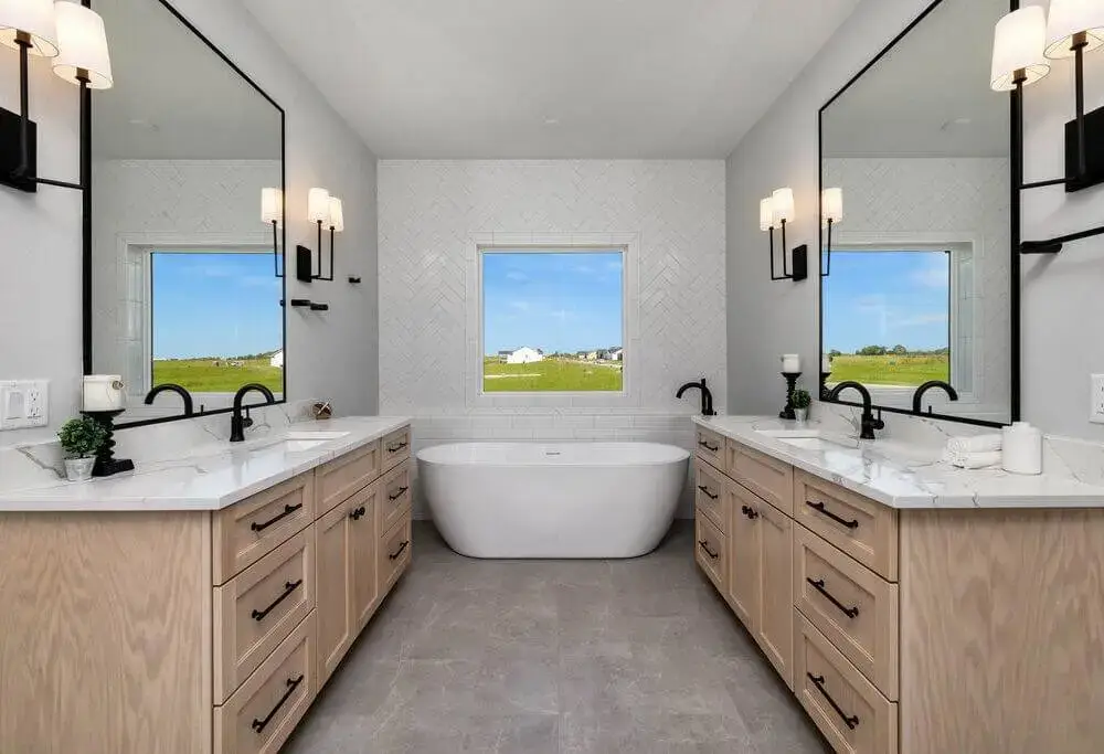 A bathroom with two vanities and a large soaker tub