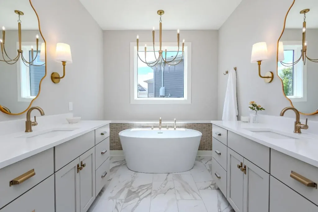 A soaker tub sits under a window and a light fixture in a luxury bathroom
