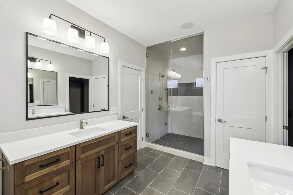 A steam shower features a floor-to-ceiling glass door