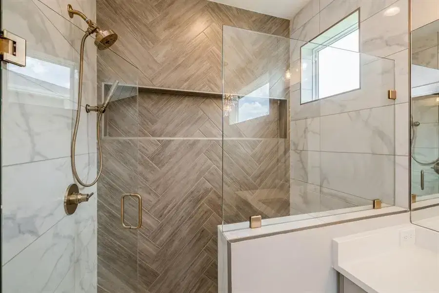 A shower interior features marble tiling on two sides and a wood panel-texture tiling on another side