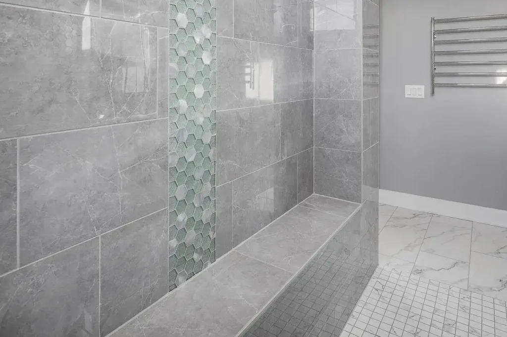 A towel warming rack sits on the wall of a bathroom near a spacious shower