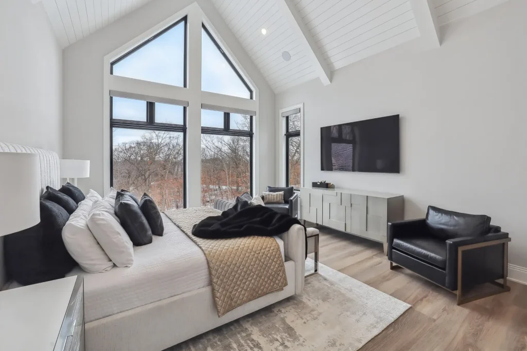 Luxury bedroom with vaulted ceiling and floor-to-ceiling windows